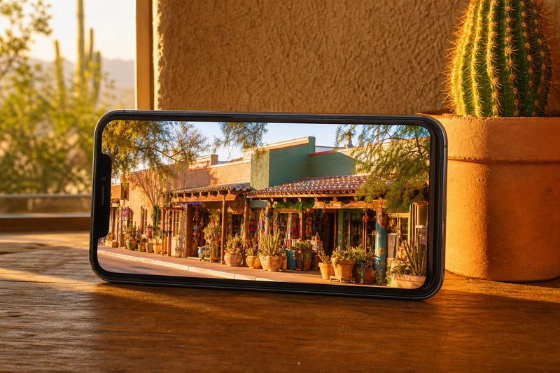 Smartphone standing on a table playing a bright video of a small Tucson shop