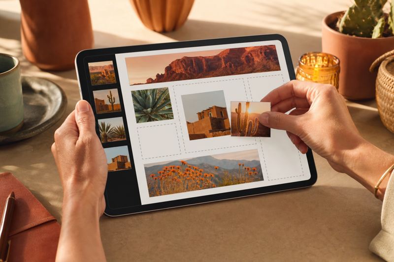 Hands arranging photo tiles on a tablet that shows a drag and drop page builder